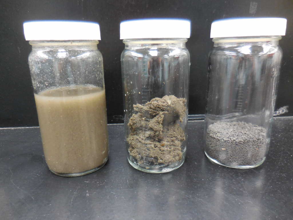 Three bottles, each containing biosolids in differing stages of processing.