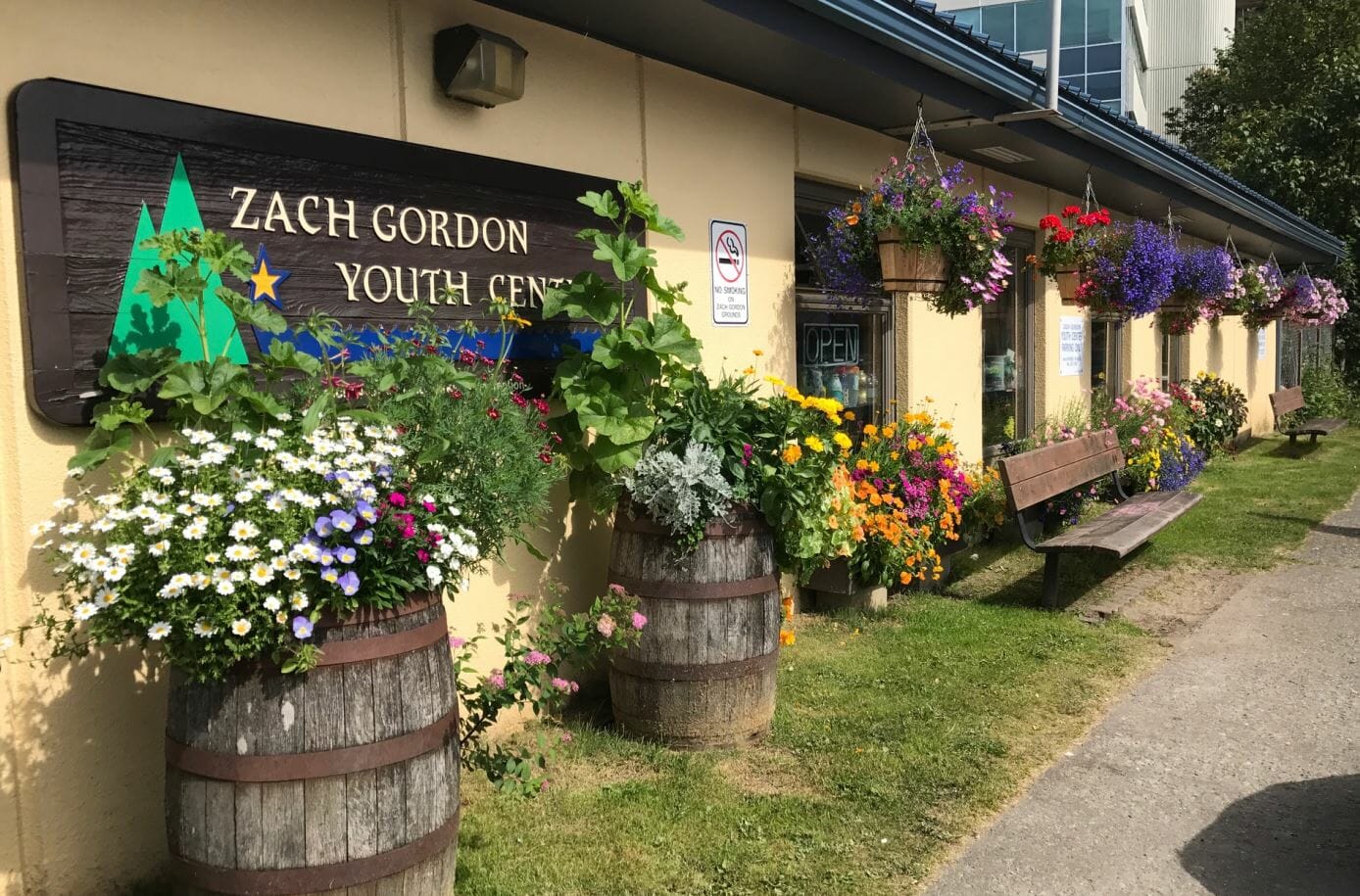 Angled view of Zach Gordon Youth Center with sign visible and flowers blooming