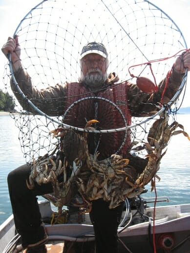 Man holding crab ring full of Dungeness Crab