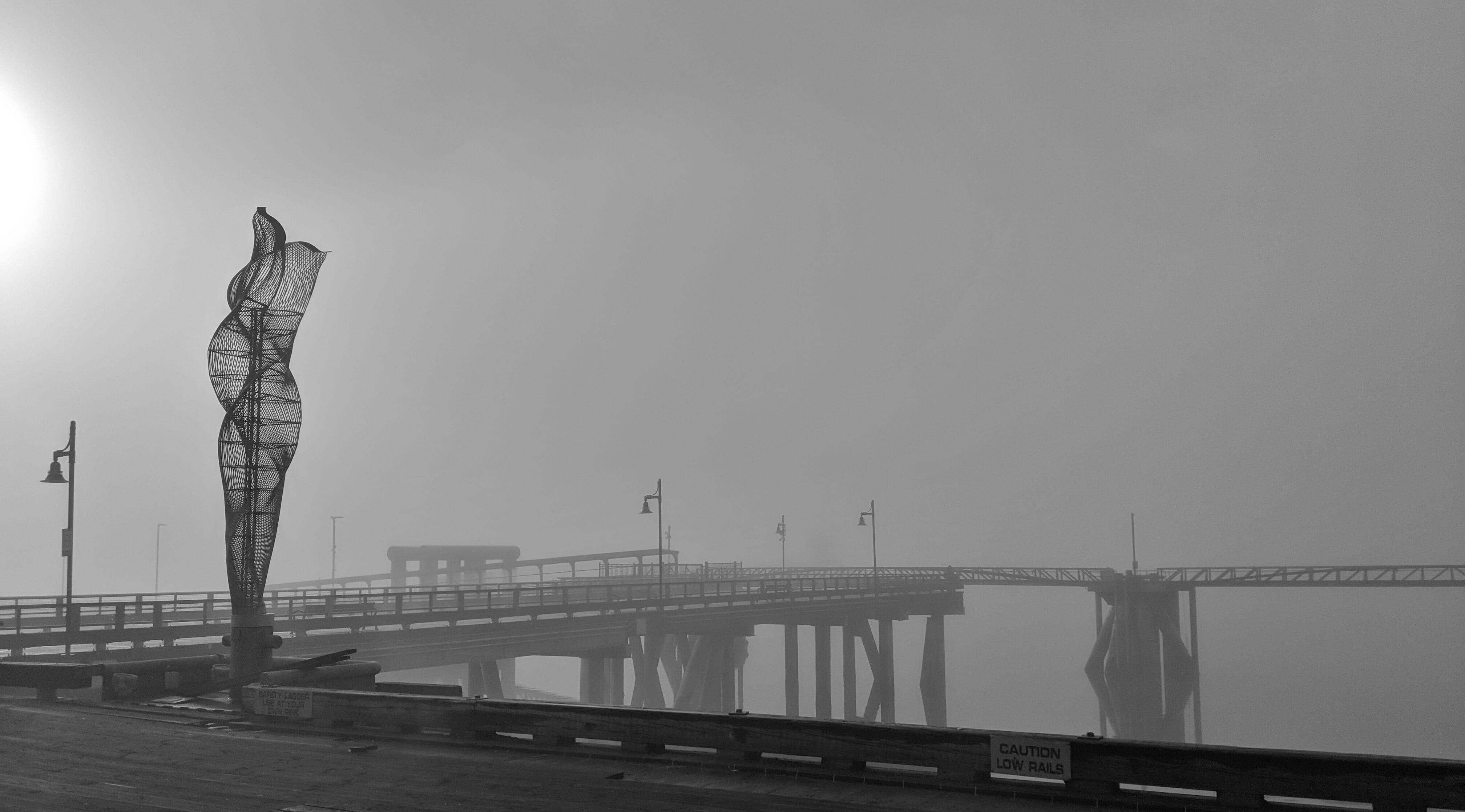 Foggy view of public art on the pier as seen from the Marine Park.