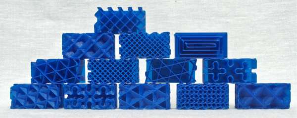 A photo of infill pattern samples printed in blue TPU 95A. Each sample is 50x20x20mm deep, and the samples are stacked into a pyramid shape with the 'top' side of each sample oriented towards the viewer.
