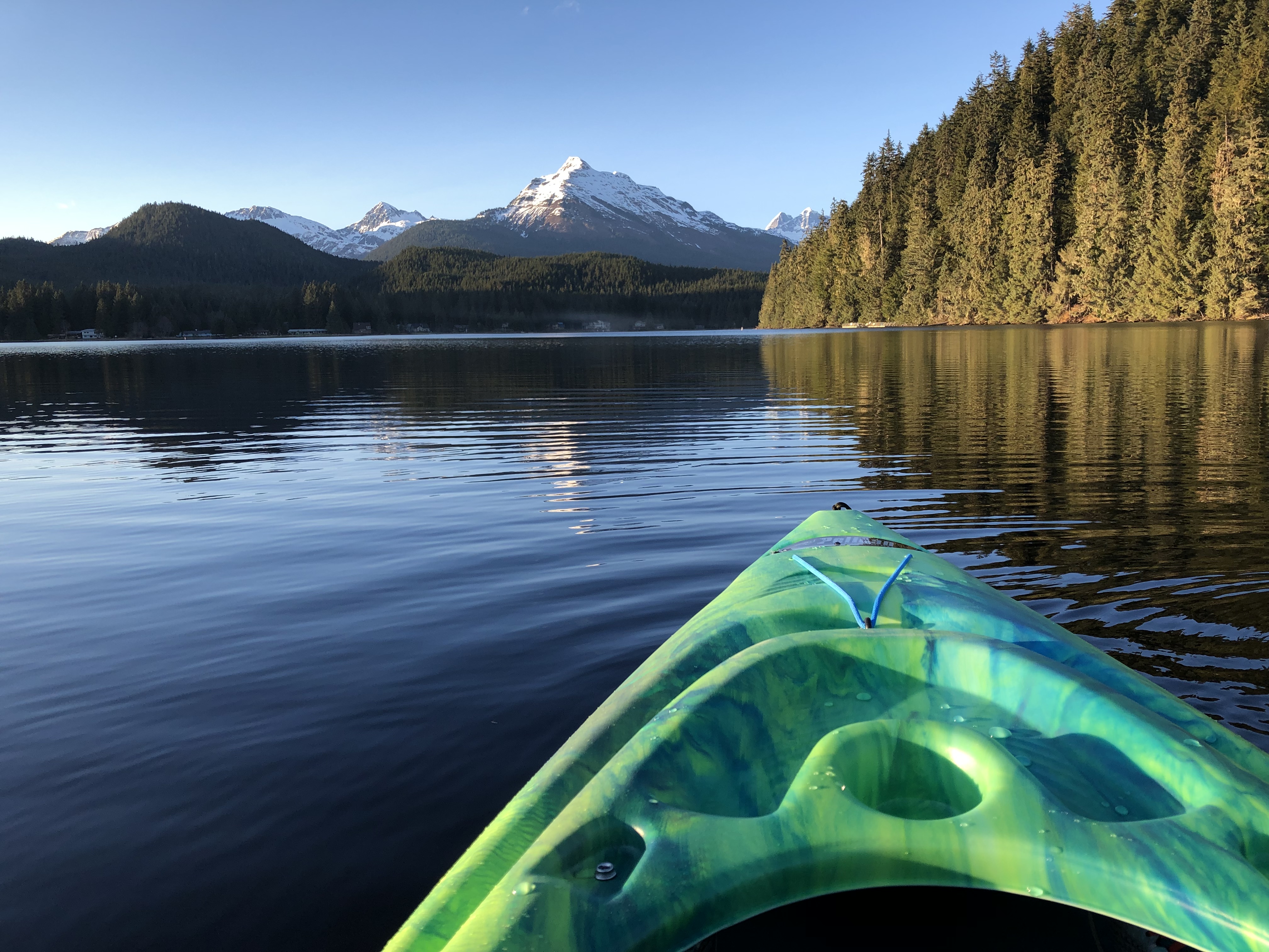 The tip a kayak on AUke Lake with Mount McGinnis in the background.