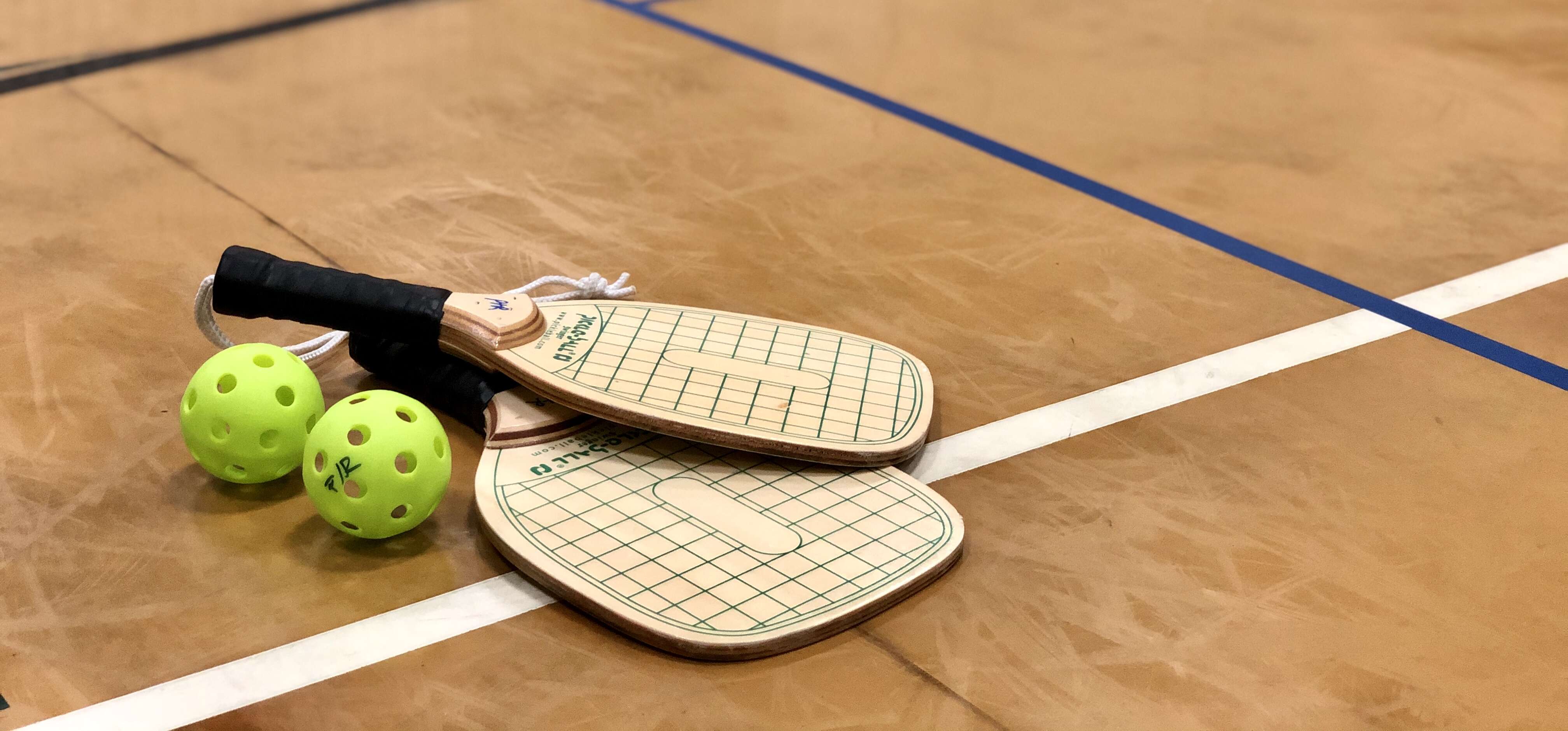 Pickleball paddles and balls on a court
