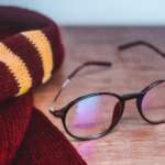 This is a picture of a Harry Potter scarf and glasses on a table.