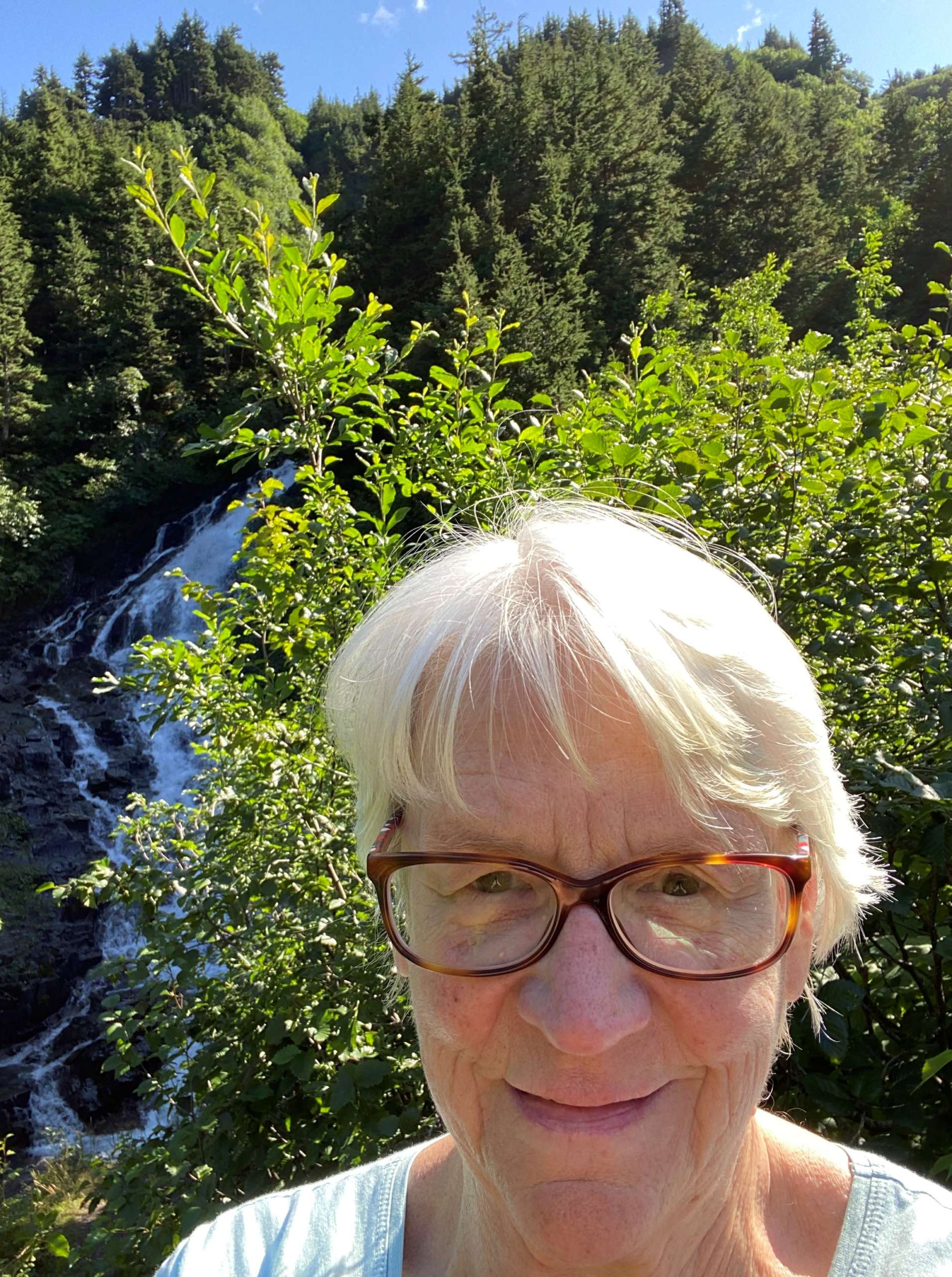 Walk SOutheast participant selfie on a trail with a waterfall.