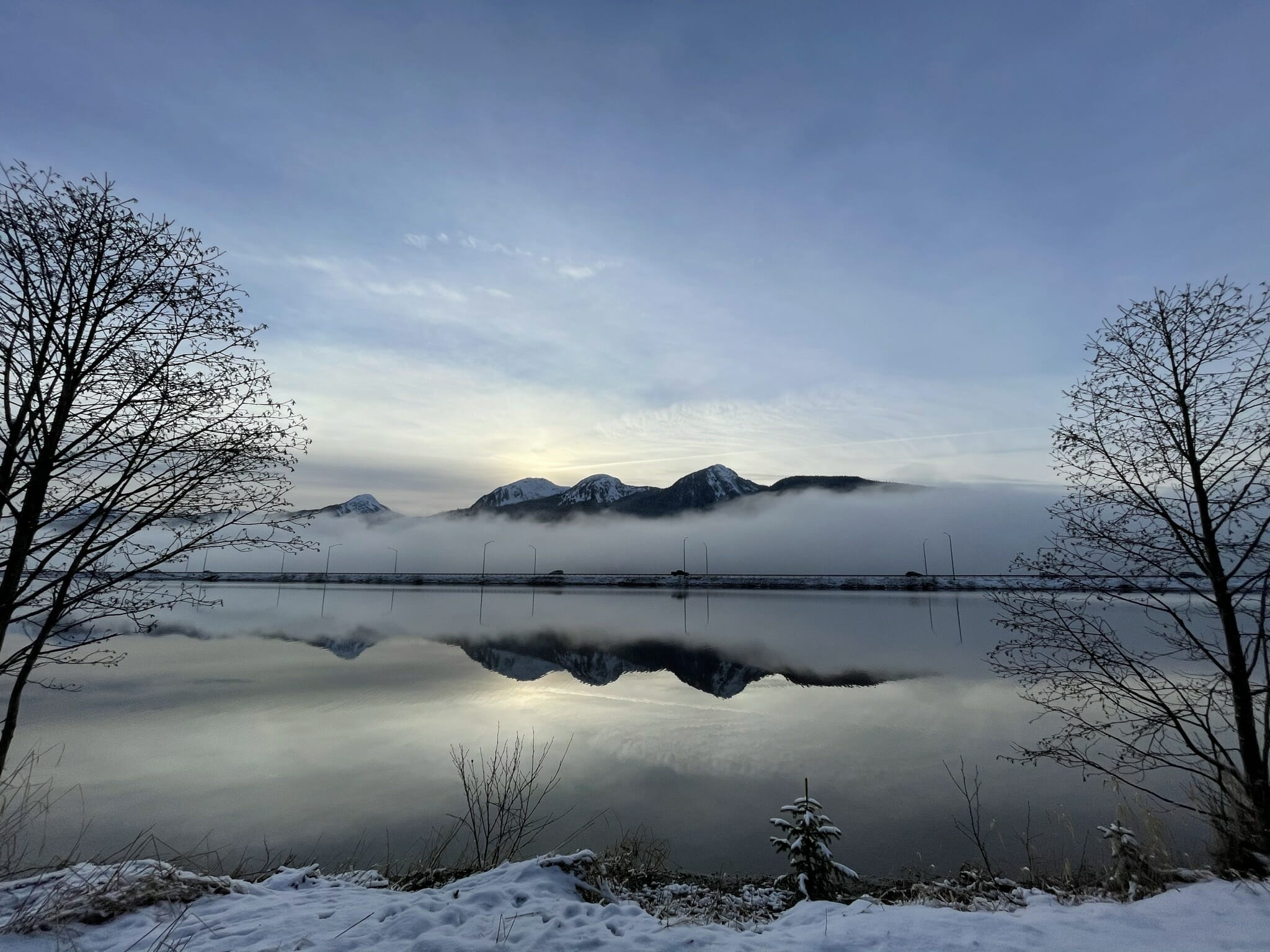 The reflection off Twin Lakes on a winter morning with fog rolling along the highway in the background.