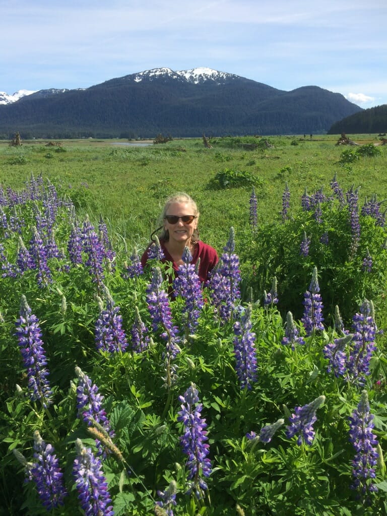 Walk Southeast 2022 participant sitting in the Lupine on the wetlands.
