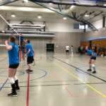 A man and woman standing at the net waiting for a serve ina volleyball match.