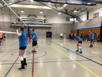 A man and woman standing at the net waiting for a serve ina volleyball match.