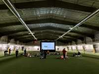 Photo of kids and adults watching a movie on the Field House turf.