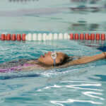 Photo of child backstroking in pool lane