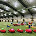 Photo of toys and play equipment waiting on the turf inside Dimond Park Field House