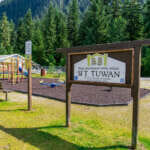 Photo of sunny playground with sign reading S'it Tuwan