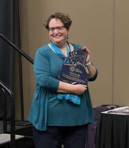 Photo of Beth McEwen holding AAMC Clerk of the Year award