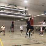 Photo of adult coed volleyball team playing indoors