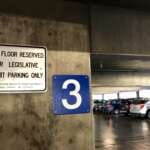 Photo of parking garage sign reading "This floor reserved for legislative permit parking only."