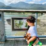Photo of small child looking at framed StoryPath page on Seawalk.