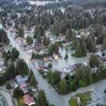 Aerial photo of neighborhood streets flooded with river water.