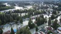 Aerial view of neighborhood streets flooded by Mendenhall River