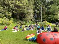 Children sprawl on the Arboretum lawn, with an inflatable lady bug in the foreground.