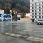 Mostly empty parking lot with buildings in the background