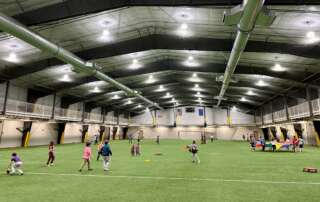 Open-Turf-Returns Children playing on indoor turf field