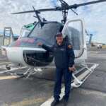 Man standing in front of rescue helicopter on tarmac
