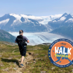 Person looks at the Mendenhall Glacier while hiking a mountain.