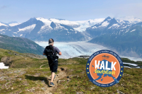 Person looks at the Mendenhall Glacier while hiking a mountain.