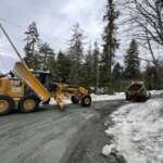 A CBJ Streets & Fleets worker uses a large truck to spread material into a pothole on Cohen Drive.