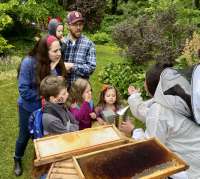 A family looks at a bug together while at Jensen-Olson Arboretum.
