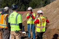 Staff from U.S. Army Corps of Engineers and City and Borough of Juneau talk while digging sand.