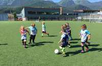 Kids play soccer on a field.
