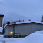 City staff shovel snow from Mendenhall River Community School during a snow storm.