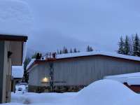 City staff shovel snow from Mendenhall River Community School during a snow storm.