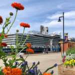 Cruise ship at a dock behind flowers.