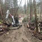 A tractor lifts debris from a trail for construction of the 35-mile ORV riding park.