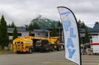 Month of Play flag in front of trucks at Thunder Mountain Middle School.