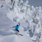 A person skis down a snowy mountain.